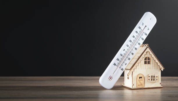 istock House model with a thermometer on the table. 1347612971