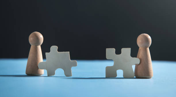 istock Wooden human figures with a jigsaw puzzles. 1347612996
