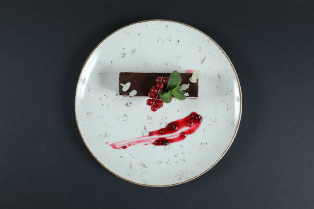 istock Well decorated fruit cake on plate in restaurant isolated on black background 1347613023