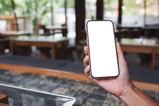 istock Mockup image of hands holding black mobile phone with blank desktop screen 1347615760