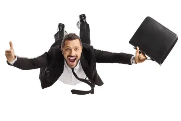 Photo of Businessman superhero with a briefcase flying and gesturing thumbs up