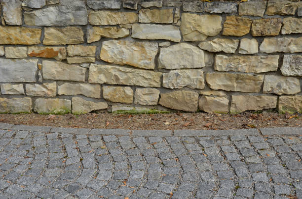 bent sandstone walls made of stone blocks serve as design elements, retaining walls, or seating areas, seats for park visitors. benches made of horizontal, cotoneaster, carpet, horizontalis, coral, marl