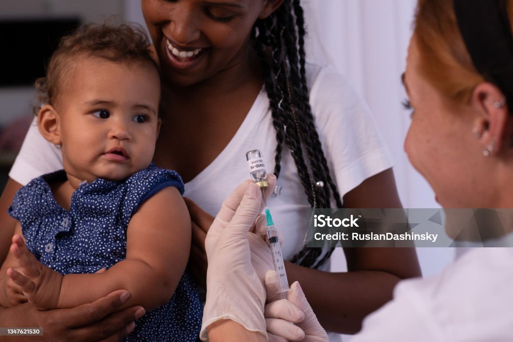 Baby vaccination. The pediatrician or nurse vaccinating baby child patient. Covid-19 vaccine. COVID-19 Vaccine Stock Photo