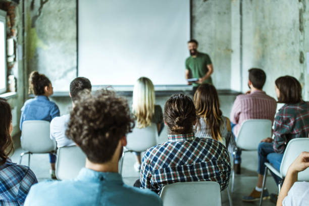 istock Back view of design professionals having training class in the office. 1347623489