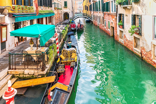 Gondola moored in a narrow street canal of Venice, Italy.