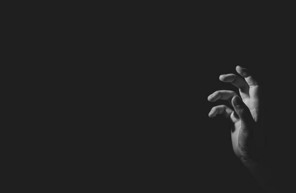 istock Hand with light and shadow, black an white, isolated on black 1347623796