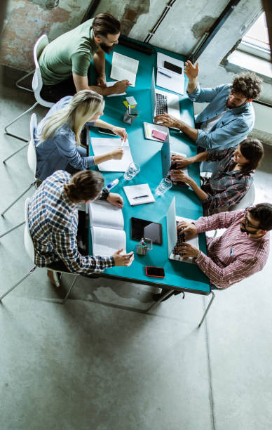 istock Above view of multi-tasking creative team working in the office. 1347624638
