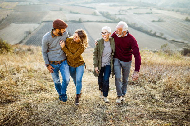 istock Two couples walking embraced up the hill in autumn day. 1347625562