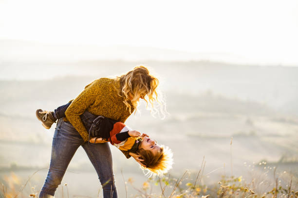 istock Playful mother having fun with her small boy on the field. 1347625875