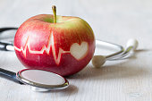 istock Heartbeat line on red apple and stethoscope, healthy heart diet concept 1347628652