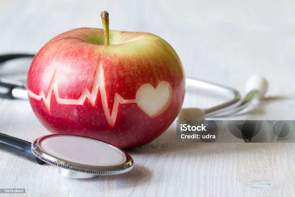 Heartbeat line on red apple and stethoscope, healthy heart diet concept Heartbeat line on red apple and stethoscope, healthy heart diet concept background Blood Pressure Gauge Stock Photo