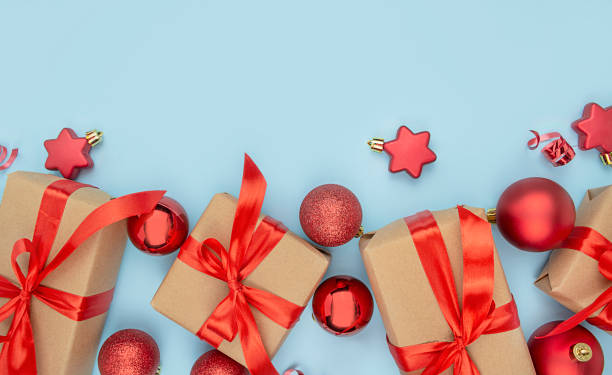 istock Christmas background with decorations and gift boxes on a light blue background. Paper gift boxes with red bows and Christmas decorations. Copy of space. 1347633049