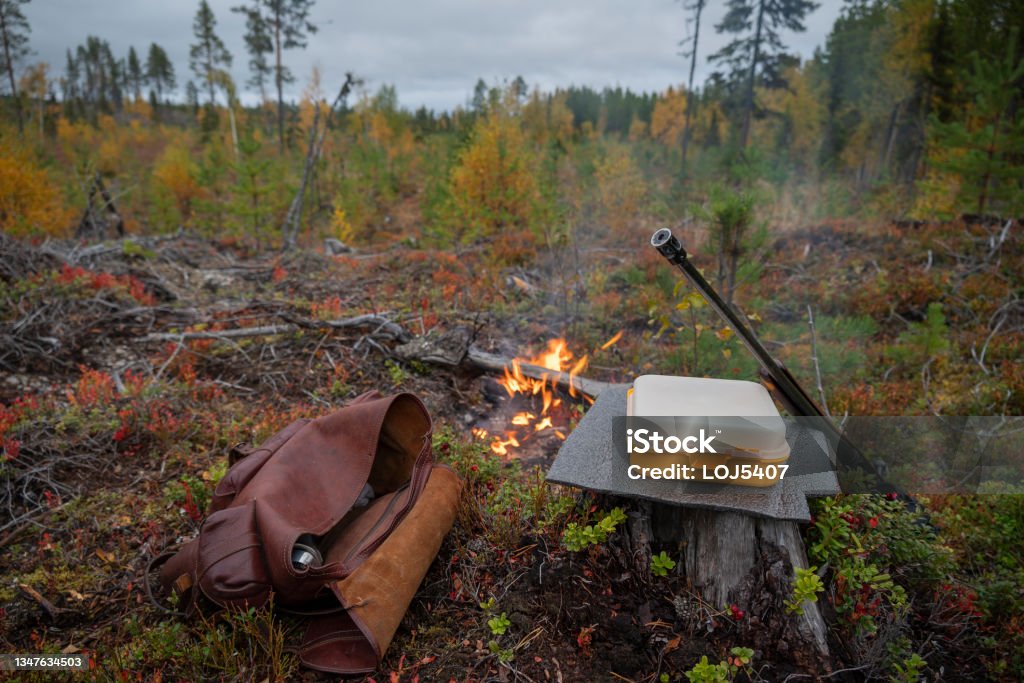 Basic equipment for moose hunting. The most important for the moose hunter, weapon, butt insulation, fire, box of sandwiches and a backpacker with a thermos with coffee, picture from the north of sweden. Hunting - Sport Stock Photo