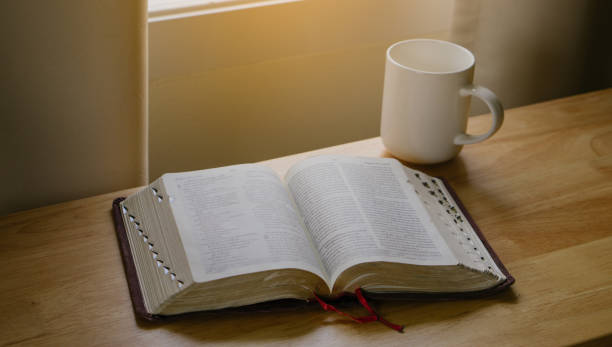 istock Open Bible and coffee in the morning on a wood table. 1347634768