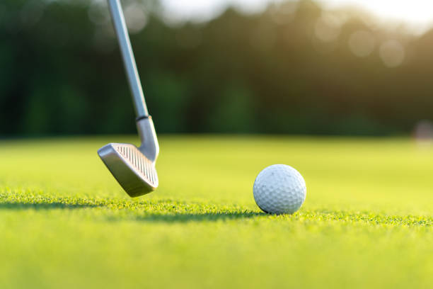 istock Golf ball with golf club on green field grass 1347639541