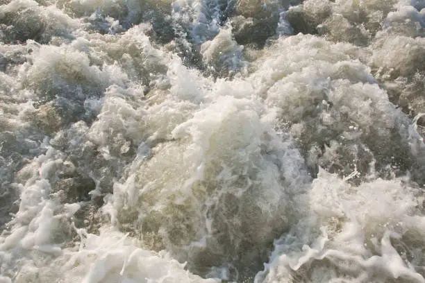 Dirty rushing water background of a river in flood