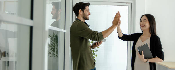enjoy and happy working business woman do High Five during talking and working with colleague man stock photo