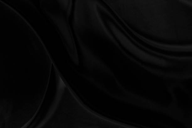 istock Black gray satin dark fabric texture luxurious shiny that is abstract silk cloth background with patterns soft waves blur beautiful. 1347643511