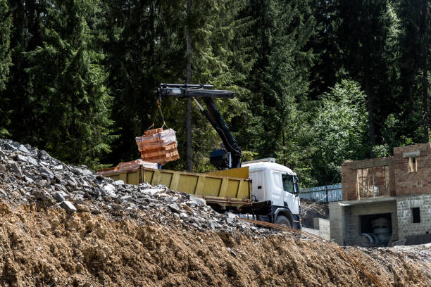 istock Side bottom pov big modern truck with mounted self loading crane arm boom unloading pallet of new bricks at countryside rural forest suburban construction site. Building materials delivery service 1347643741