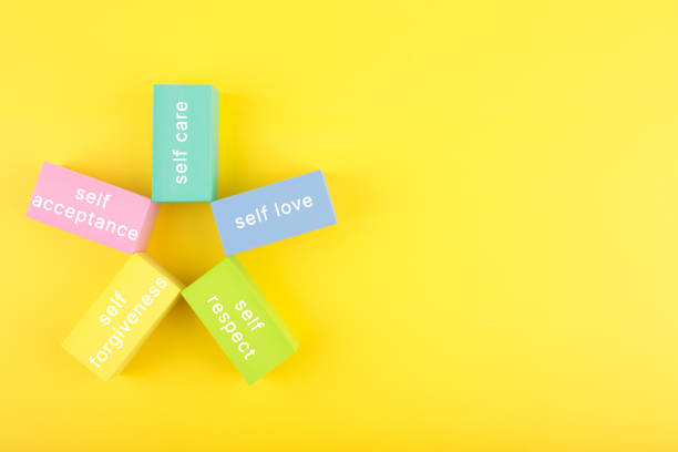 istock Mental health formula concept. Self acceptance, self care, self respect and self forgiveness written on flower from multicolored rectangles on yellow background with copy space 1347643947