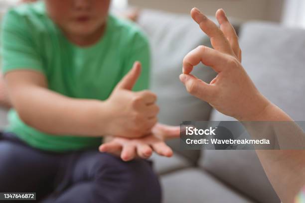 Boy Using Sign Language Two Caucasian Boys Communicating Using Sign Language While Sitting On ...