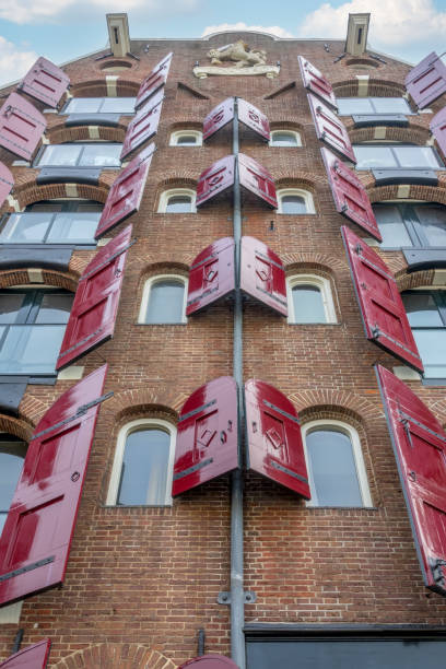 istock Old House in Amsterdam With Red Shutters on the Windows 1347648134