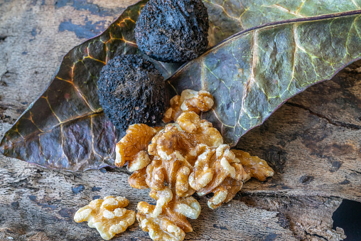 fresh black walnuts on leaf, in shell and out of shell