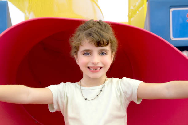 istock brunette indented girl smiling in red playground 1347650290