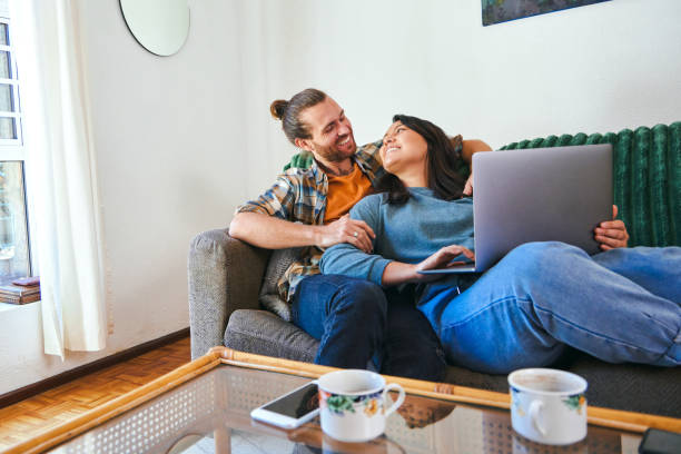 istock Shot of a young couple relaxing together while using their laptop 1347650317