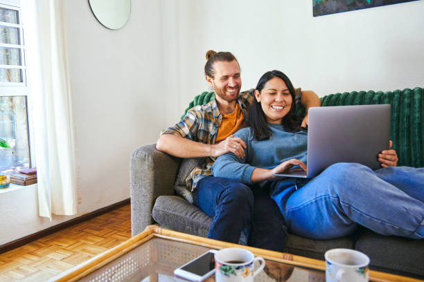 istock Shot of a young couple relaxing together while using their laptop 1347650321