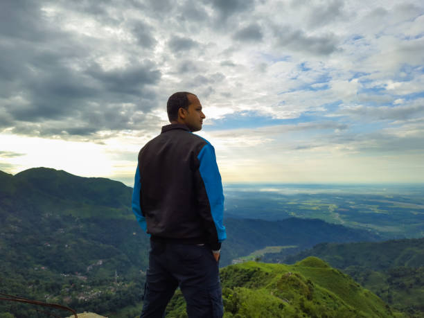 istock man standing at mountain top with dramatic sky at morning 1347652148