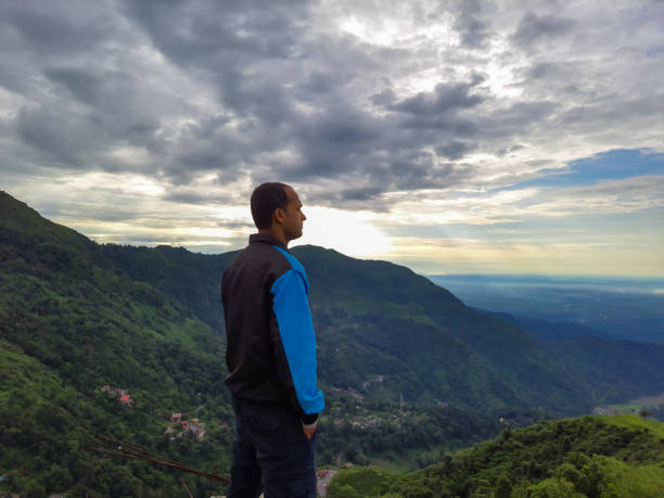 istock man standing at mountain top with dramatic sky at morning 1347652458