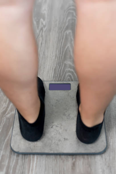 istock Close-up of a man weighing himself on a scale 1347653412
