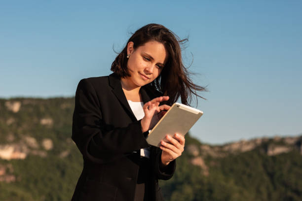 istock Smiling businesswoman working and using tablet in nature 1347653946