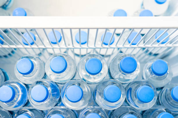 istock Rows of many transparent plastic bottles with drinking water supply in white refrigerator. Mineral water stack storage in fridge to drink on hot summer day. Healthcare and dehydration prevention 1347655054
