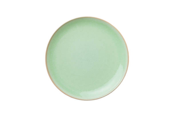 istock Green ceramic round plate isolated over white background. Top view 1347655364