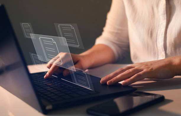 istock Businesswoman working on   laptop with virtual screen. Process automation to efficiently manage files. Online documentation database and  document management system concept. 1347656537