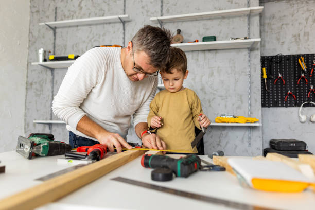 istock Little boy assisting to his father in carpentry workshop 1347657270