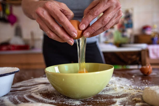 istock Close up of a woman cracking an egg 1347658053