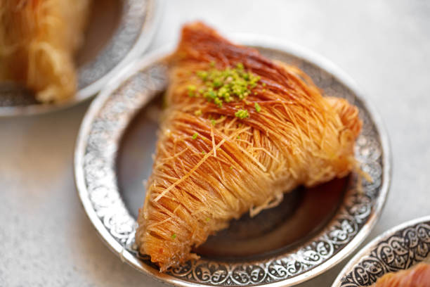 istock Turkish baklava on oriental metal plate on white table 1347658107