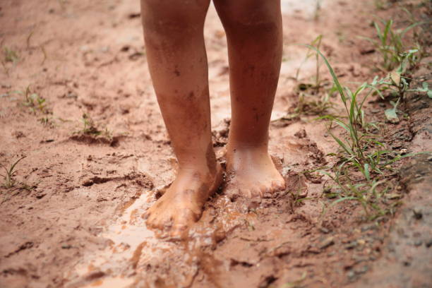 istock Kid playing in the mud after rain 1347661952