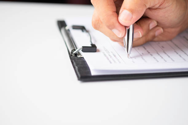 istock Image of Hand using writing pen with questionnaire or paperwork survey question filling 1347663644