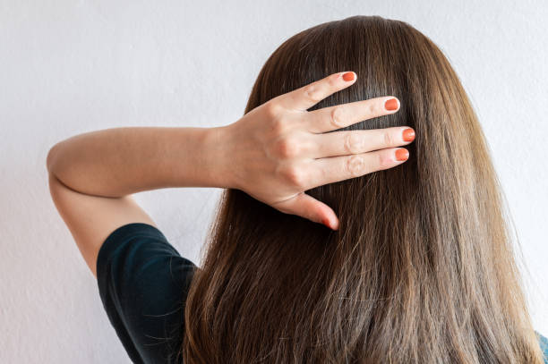 Rear view of young Asian woman touching her thick hair. Thick hair technically refers to the width of a single strand of hair, whereas hair density refers to the number of strands on your head. frizzy stock pictures, royalty-free photos & images