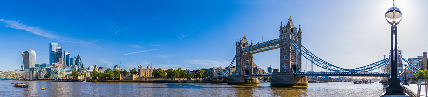 The iconic battlements of Tower Bridge spanning the River Thames at Southwark overlooked by the futuristic skyscrapers of the City of London Financial District, UK.