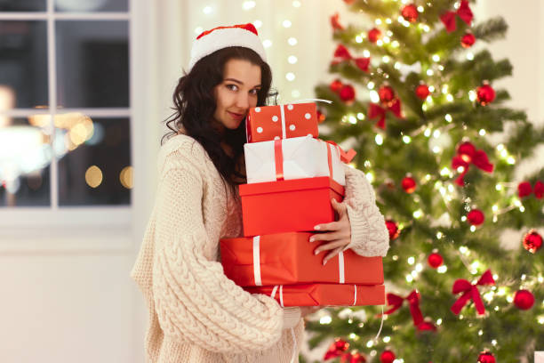 自宅で贈り物を持つ面白いクリスマスサンタの女性 - christmas emotional stress shopping holiday ストックフォトと画像