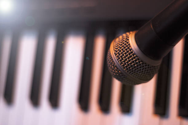 istock Microphone over piano keys in dim light. No people 1347668551