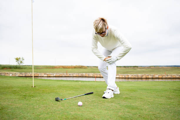 golfista sênior com problemas de saúde e dor no joelho no treinamento de golfe. - golf green practicing sports training - fotografias e filmes do acervo