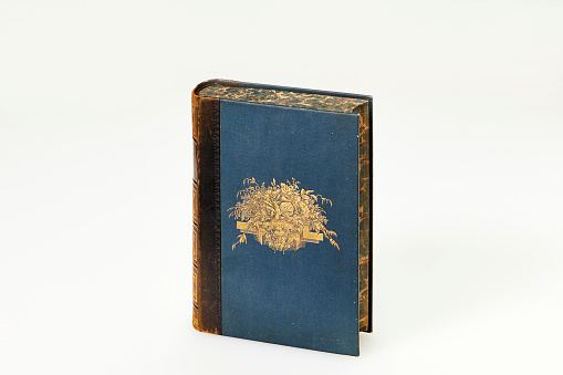 Old weathered, grungy Holy Bible sat on a dark stained wooden background with space for copy