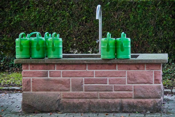 Watering cans at the cemetery, standing on the well