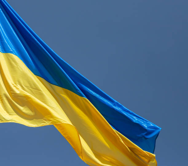 istock Ukraine flag waving on the wind against the blue sky 1347675047